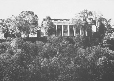 Black and white photo of the Hunter mansion surrounded by trees.
