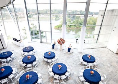 An aerial shot or dark blue round tables set up in the lobby of the Hunter Museum.