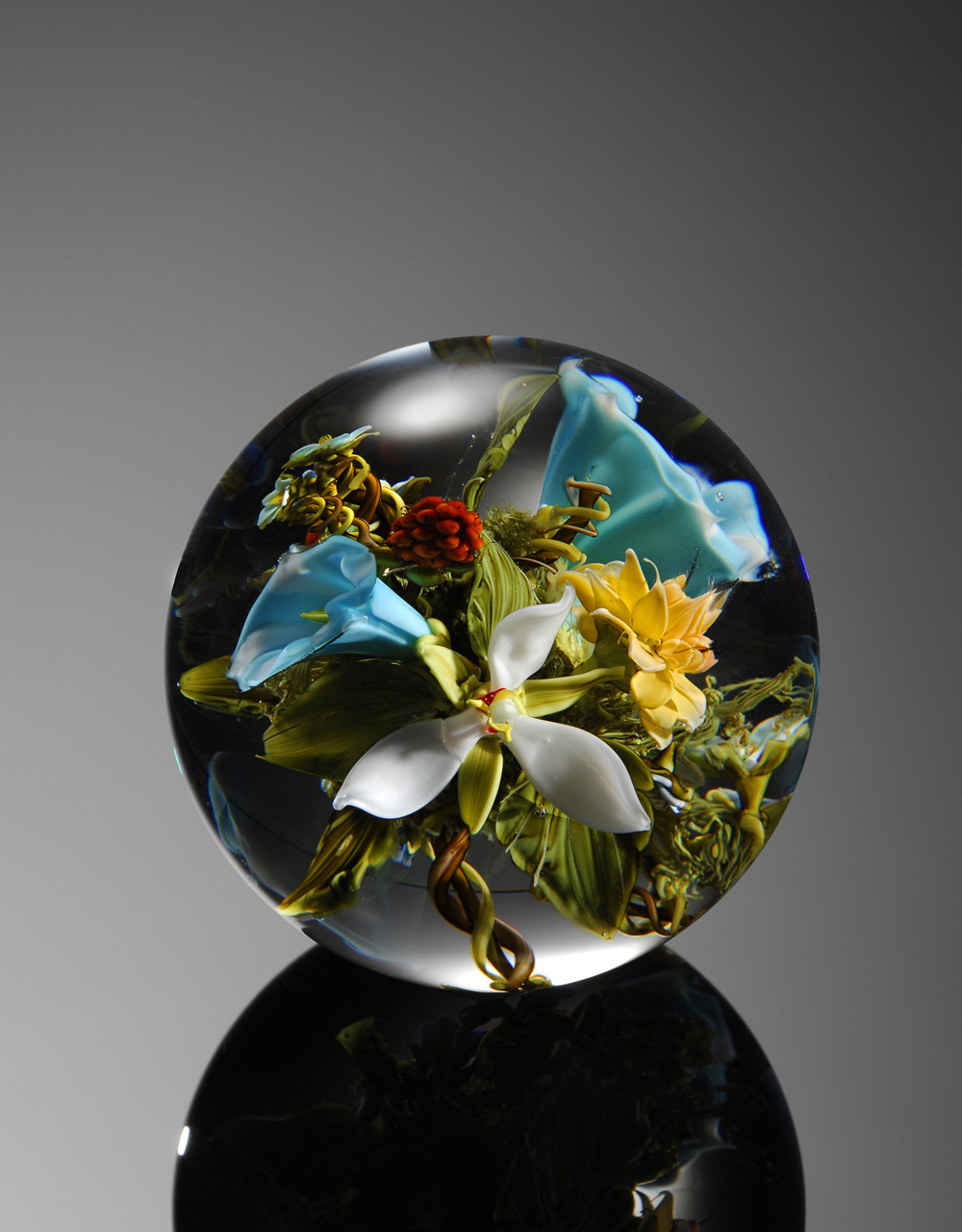 A resin globe filled with flowers against a grey background.