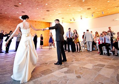A bride and groom dance with their guests around them in the Hunter Museum.