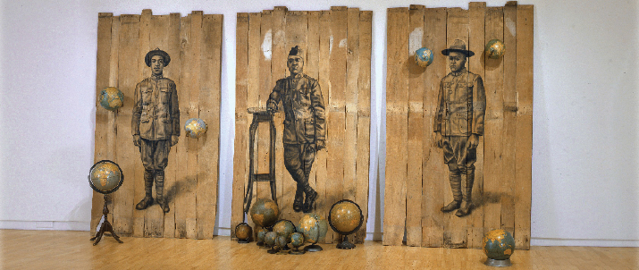 Three panels made of wooden planks with soldiers imprinted on them. There are also globes on the panels and globes on the floor.