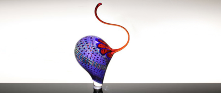 A blown glass sculpture with a slender curved neck.