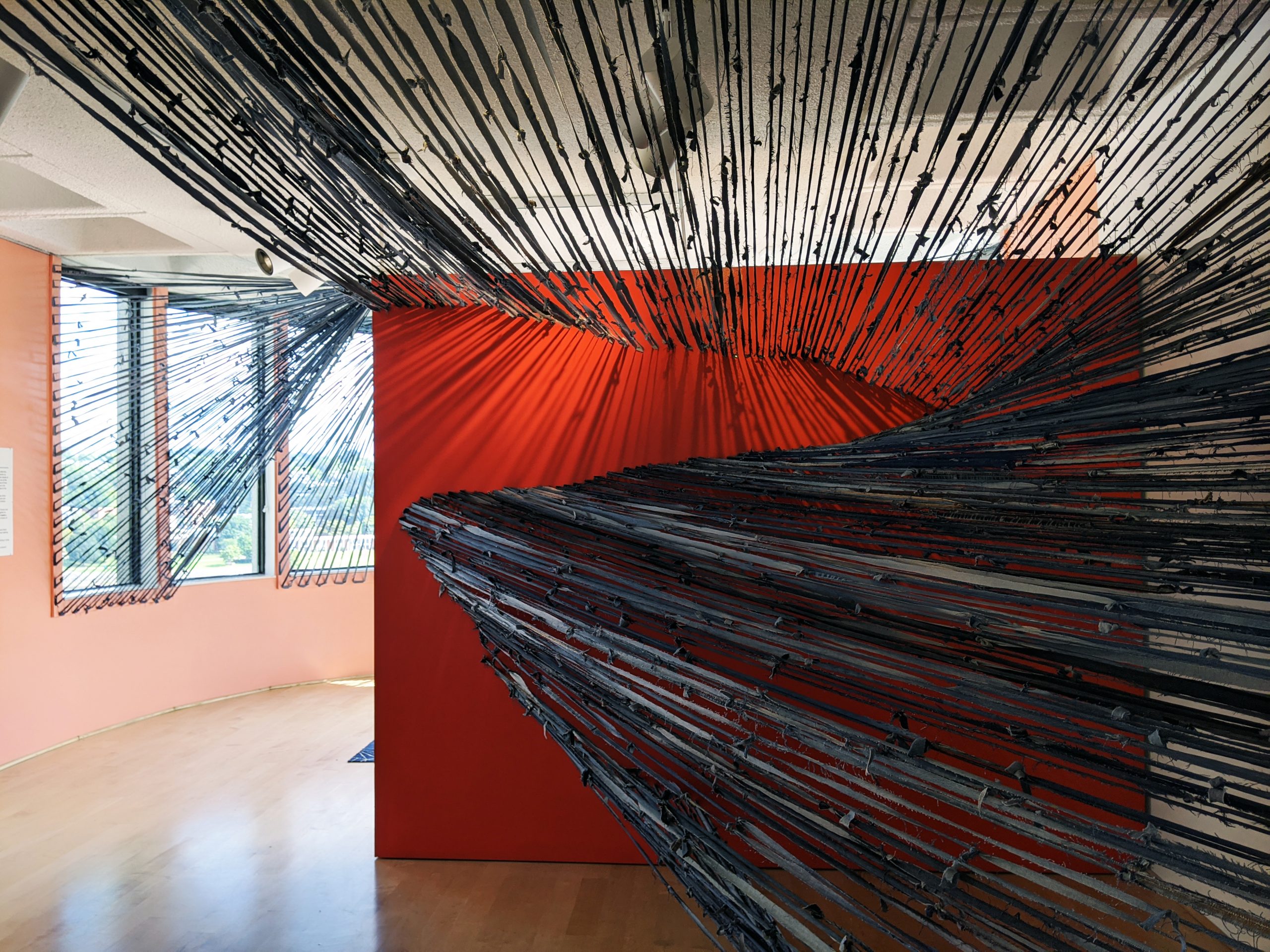 Strips of denim attached to two walls stretched across a room.